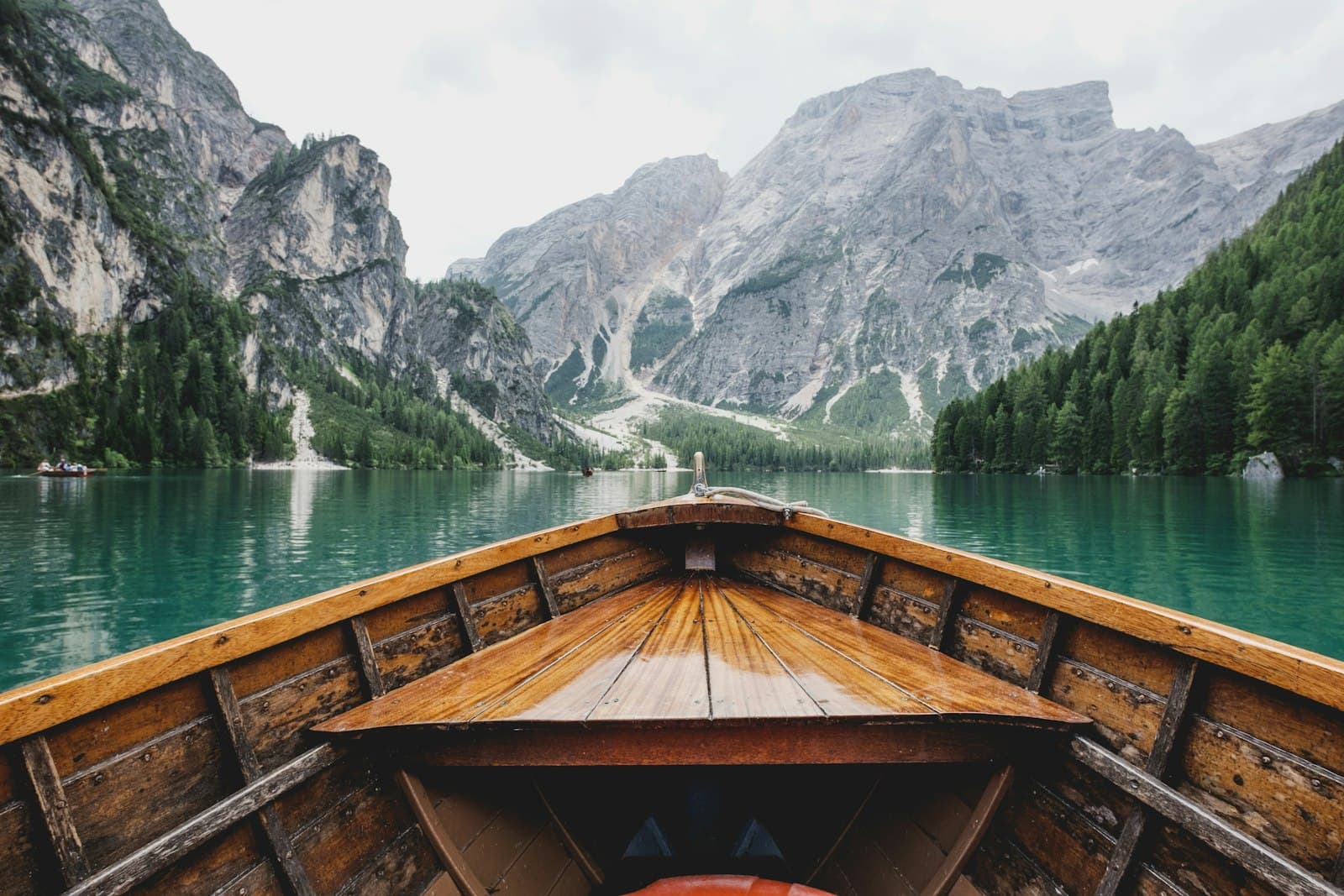 Wooden canoe gliding across a turquoise alpine lake