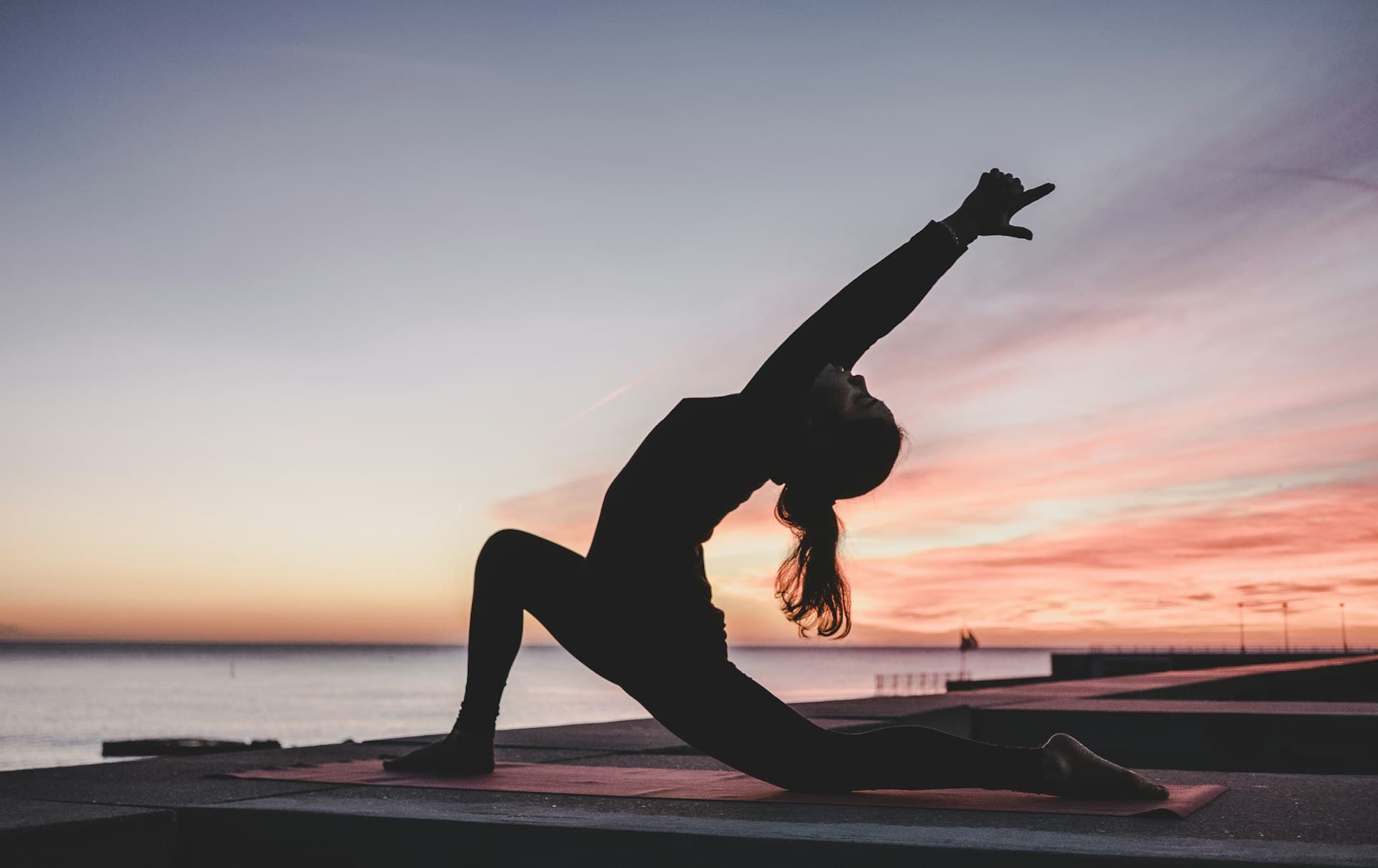 Silhouette of woman doing yoga at sunrise
