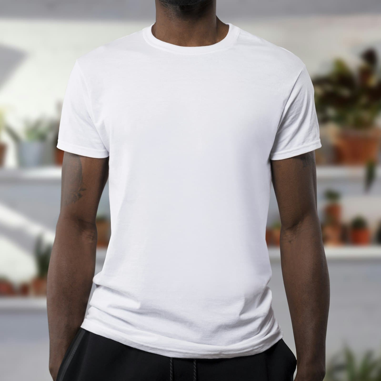 Plain white tee worn against a blurred bright background